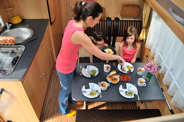 Família comendo juntos em RV (campista) interior — Fotografia de Stock