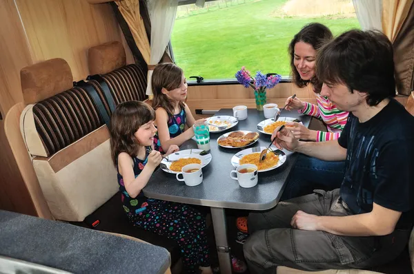 Family eating together in RV interior — Stock Photo, Image