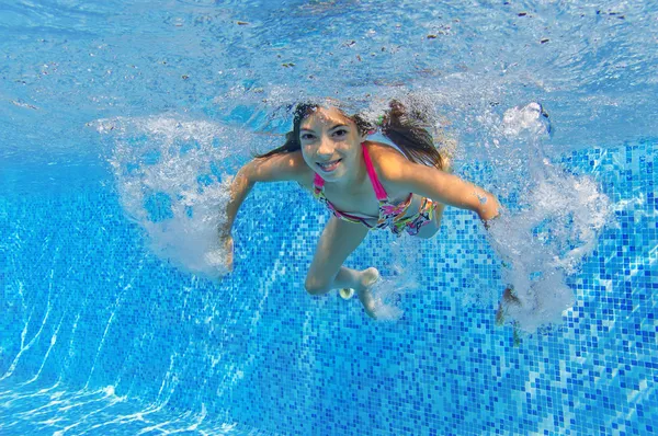 Criança ativa feliz nada debaixo d 'água na piscina — Fotografia de Stock