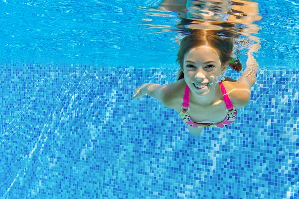 Criança ativa feliz nada debaixo d 'água na piscina — Fotografia de Stock