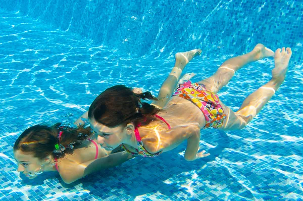 Crianças ativas felizes nadam debaixo d 'água na piscina — Fotografia de Stock