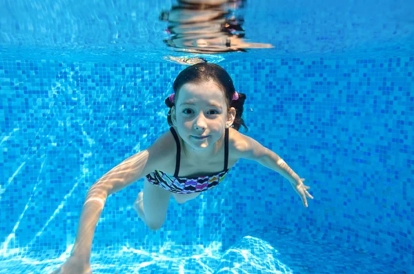 Glückliches aktives Kind schwimmt unter Wasser im Pool — Stockfoto