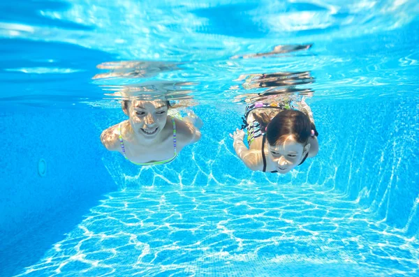 Meninas felizes nadar debaixo d 'água na piscina — Fotografia de Stock