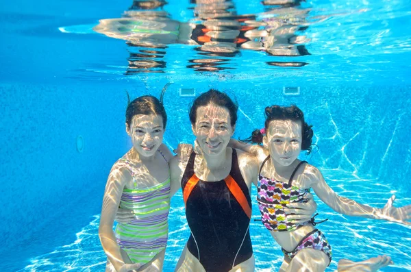 Familia feliz nadar bajo el agua en la piscina — Foto de Stock