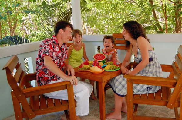 Семья ест фрукты на террасе — стоковое фото