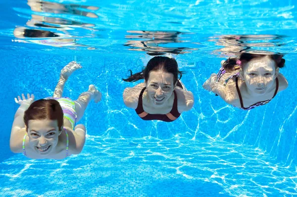 Familia feliz nadar bajo el agua en la piscina y divertirse —  Fotos de Stock