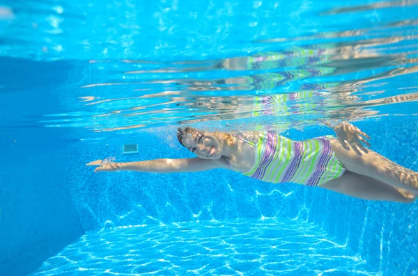 Gelukkig actieve kind zwemt freestyle in het zwembad — Stockfoto