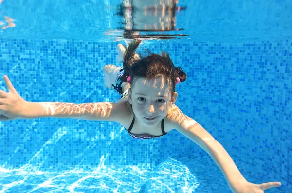Criança ativa feliz nada debaixo d 'água na piscina — Fotografia de Stock