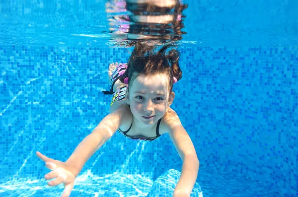 Szczęśliwy aktywne dziecko pływa pod wodą w basenie — Zdjęcie stockowe
