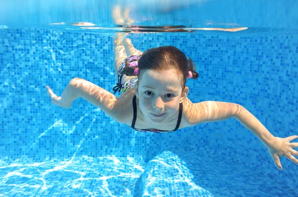 Boldog aktív gyermek úszik víz alatt a medence — Stock Fotó