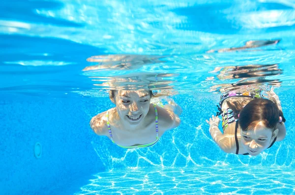 Meninas felizes nadar debaixo d 'água na piscina — Fotografia de Stock