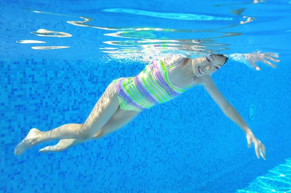 Glückliches aktives Kind schwimmt unter Wasser im Pool — Stockfoto