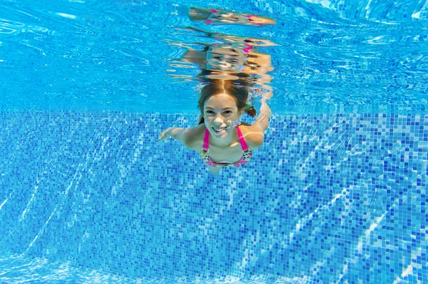 Glückliches aktives Kind schwimmt unter Wasser im Pool — Stockfoto