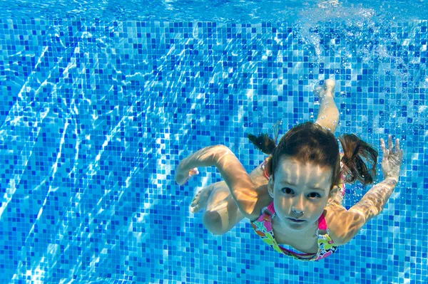 Boldog aktív gyermek úszik víz alatt a medence — Stock Fotó