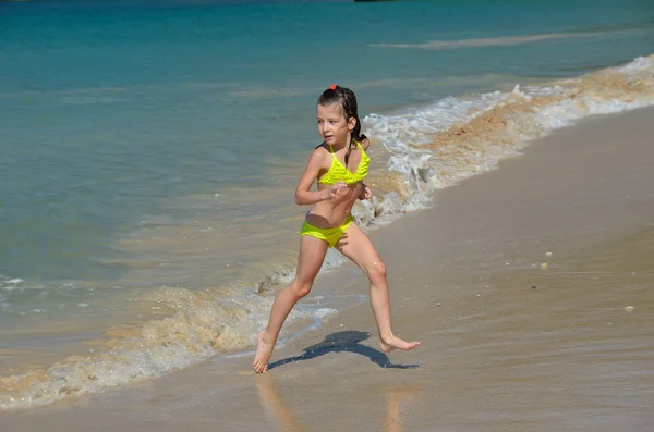 Happy girl plays in sea on tropical beach — Stock Photo, Image