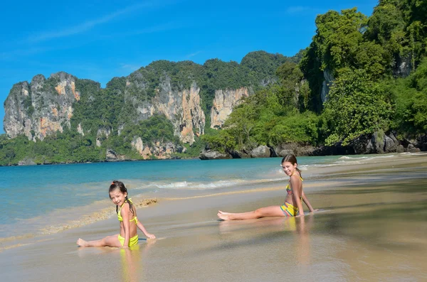 Happy girls play in sea on tropical beach — Stock Photo, Image