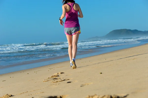 Kvinna löpare ben i skor på stranden — Stockfoto