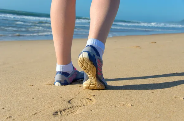 Läuferbeine in Schuhen am Strand — Stockfoto
