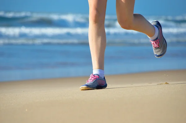 Kobieta lekkoatletka nogi w buty na plaży — Zdjęcie stockowe