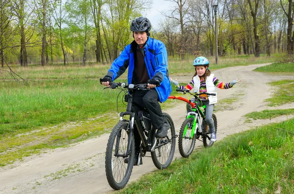 Lycklig far och barn på cyklar, familjen cykling utomhus — Stockfoto