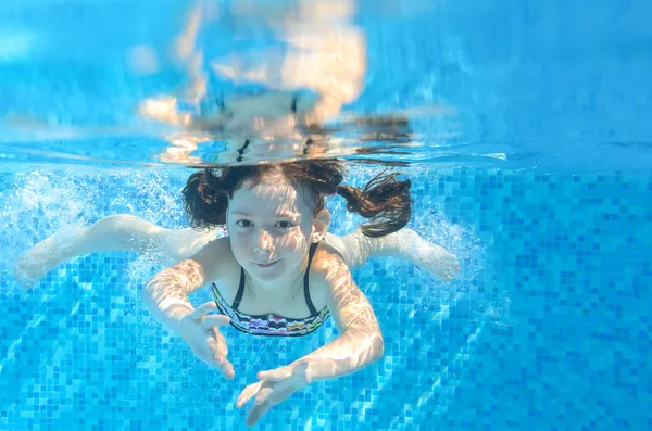 Feliz niño activo bajo el agua nada en la piscina —  Fotos de Stock