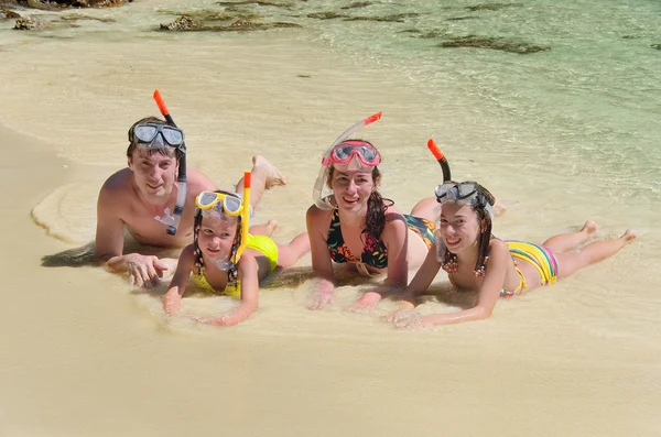Happy family in snorkels on tropical beach — Stock Photo, Image