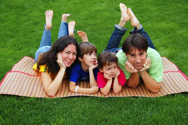 Familia con dos hijos en la hierba —  Fotos de Stock