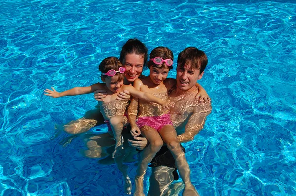 Família feliz se divertindo na piscina — Fotografia de Stock