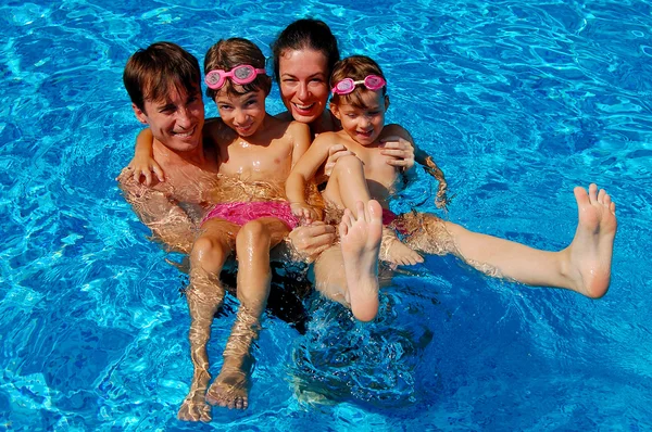 Mutlu aile yüzme havuzunda eğleniyor.