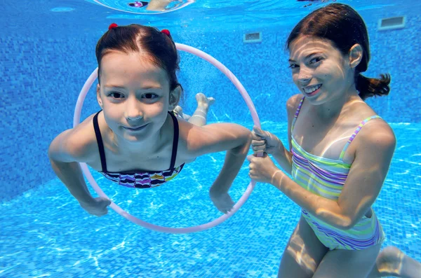 Niños activos felices juegan bajo el agua en la piscina —  Fotos de Stock