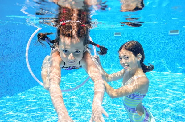 Gelukkig actieve kinderen spelen onderwater in zwembad — Stockfoto