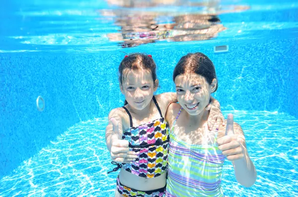 Niños activos felices juegan bajo el agua en la piscina —  Fotos de Stock