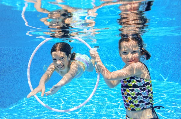 Niños activos felices juegan bajo el agua en la piscina —  Fotos de Stock