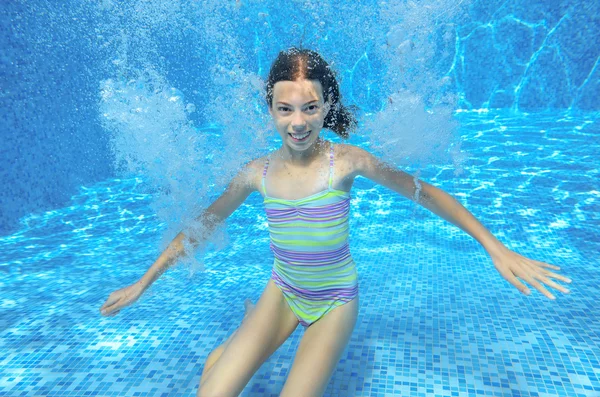 Šťastné dítě aktivní pod vodou plave v bazénu — Stock fotografie