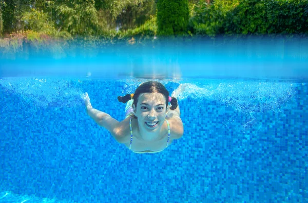 Child swims in swimming pool, underwater and above view — Stock Photo, Image