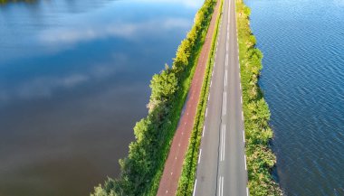 Otoyol manzarası ve polder barajındaki bisiklet yolu, Kuzey Hollanda, Hollanda 'dan gelen arabalar.