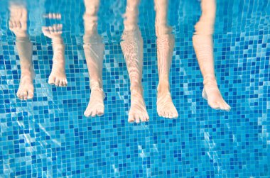 Aile bacakları yüzme havuzunda, anne çocuklarla su altında yüzer komik bir konsept, spor ve çocuklarla tatil