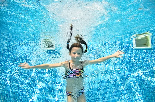 水中でのスイミングプールでの子供の水泳 小さなアクティブな女の子のジャンプ ダイビング 水中での楽しみ 子供のフィットネス 家族の休暇でのスポーツ — ストック写真