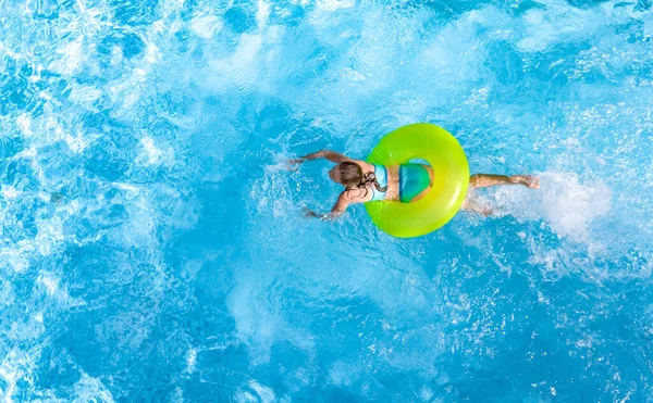 活跃的少女在游泳池空中俯瞰 孩子们在充气的环形甜甜圈上放松和游泳 在家庭度假 热带度假胜地玩水玩乐 — 图库照片
