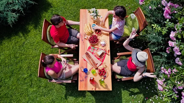 夏のガーデンパーティーで一緒に屋外で食べる家族や友人 上から食べ物や飲み物とテーブルの空中ビュー レジャー ピクニックのコンセプト — ストック写真