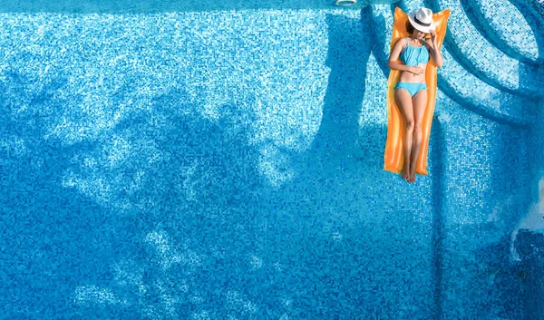 위에서 바라보는 수영장 꼭대기에서 아름다운 모자를 비키니를 매트리스를 수영하는 물마시는 — 스톡 사진