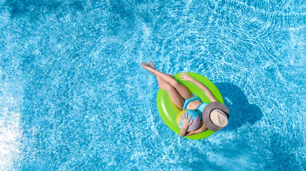 在游泳池里活动的年轻女孩从上方俯瞰着 青少年们在充气的环形甜甜圈上放松和游泳 在家庭度假 热带度假胜地玩水玩乐 — 图库照片