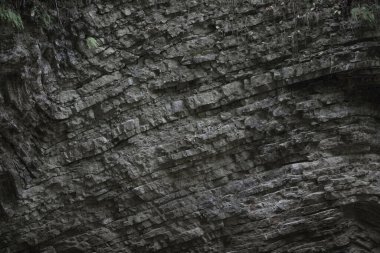 Doğal kaya, katmanlı yapı. Paralel taş şeritler. Gün ışığı.