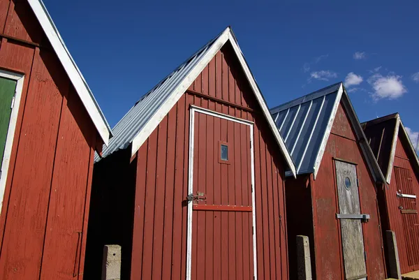 Belles cabanes de pêche rouges sur la côte — Photo