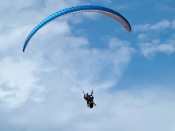 Gleitschirmfliegen bei strahlend blauem Himmel — Stockfoto