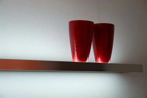 Moderne rote Vasen im Regal — Stockfoto