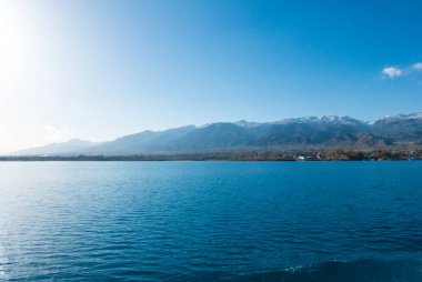 Kırgızistan, Issyk-Kul Gölü 'nün Sverny kıyısında. Gemiden sahile bak. Dağ gölünün mavi suyu. Doğal manzara..