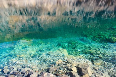 Zümrüt berrak su ve doğal taşların dokusu. Doğal arka plan. Mavi Göl. Keskin taşlar..