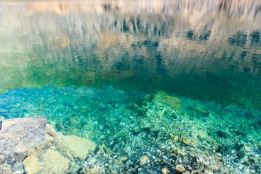 Zümrüt berrak su ve doğal taşların dokusu. Doğal arka plan. Mavi Göl. Keskin taşlar..