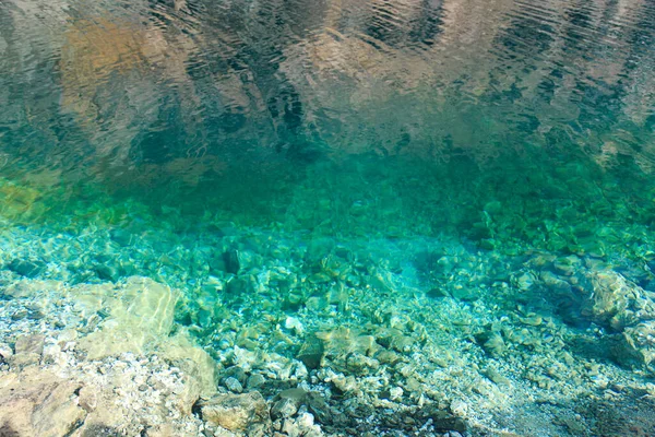 エメラルドクリアの水と天然石の質感 自然な背景 青い湖 鋭い石 — ストック写真